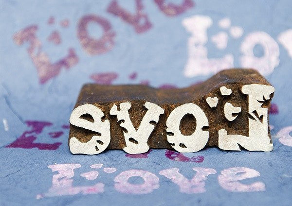 A wood block stamp with the word 'love' inscribed